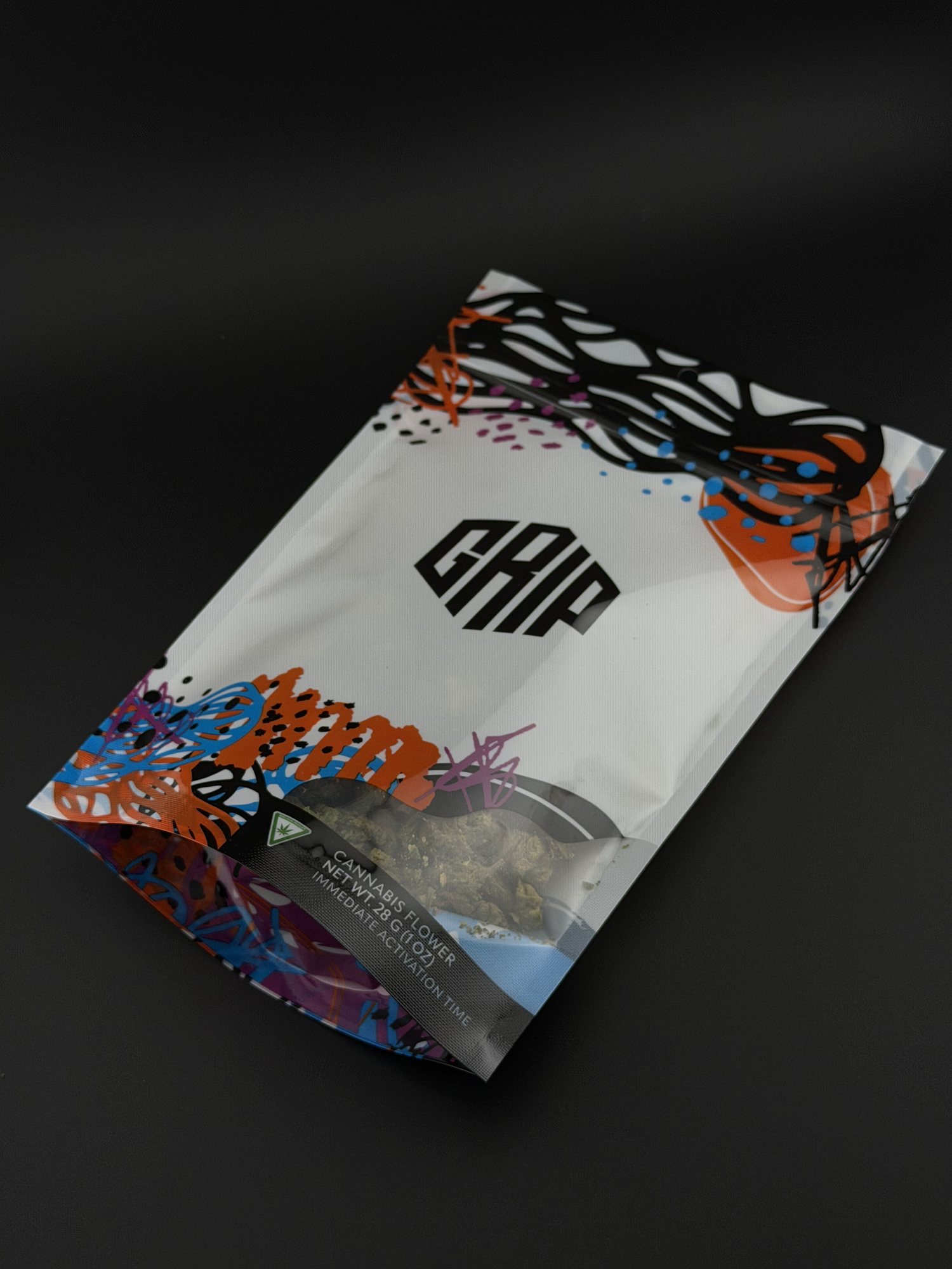A sealed Grip pre-pack of flower held up in front of the canopy